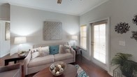 This single-story residence is designed with a consistent aesthetic that carries throughout every room, anchored by rich dark hardwood-style flooring, crisp crown molding, and neutral gray-toned walls that create a calm, cohesive atmosphere.

The kitchen is a functional centerpiece, featuring dark espresso cabinetry with brushed nickel hardware, light countertops, black appliances including a refrigerator, electric range, and built-in microwave, as well as a center island that provides additional prep and storage space. Recessed lighting and a dedicated sink area complete the well-organized layout.

The living area offers a comfortable, open feel with a ceiling fan, natural light from windows fitted with wood blinds, and easy flow into adjoining spaces via wide doorways and a connected hallway.

Multiple bedrooms are present, each outfitted with ceiling fans, crown molding, dark wood furniture-height baseboards, and generous closet space — at least one bedroom includes a walk-in closet. The rooms offer a calm, restful ambiance.

Two bathrooms serve the residence. One includes a tub-shower combination with tile surround, while the other features a dark vanity with a white countertop and hardwood-style flooring, both finished with crown molding for a polished look throughout.