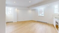 Located in the desirable Westmount neighbourhood of Quebec, this well-appointed 2-bedroom, 1-bathroom unit offers a clean, modern aesthetic throughout its single-level layout. Light hardwood flooring flows seamlessly across every room, complementing the bright white walls and recessed lighting that give the space an open, airy feel.

A central hallway connects the living areas, providing a logical and functional flow between rooms. Both bedrooms are finished with the same warm hardwood floors and crisp white walls, with windows that invite natural light and offer views of the surrounding streetscape. The primary bedroom features a sliding door for a sleek, space-conscious design. Baseboard heating units are present in both bedrooms, ensuring comfortable year-round living.

The bathroom is finished to a high standard, featuring large-format neutral tile on the walls and floors, a soaker tub with a glass panel enclosure, a multi-function shower fixture, and a mirrored medicine cabinet — creating a refined, spa-like atmosphere.

The kitchen, visible in the dollhouse view, includes stainless steel appliances and cabinetry, maintaining the unit's consistent modern character. The overall ambiance is minimal, clean, and move-in ready, making this Westmount unit a practical and elegant urban residence.