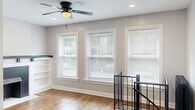 Located in Chicago's Edgewater neighborhood, this two-floor, 4-bedroom, 2-bathroom home blends classic character with modern updates throughout. The upper floor features warm hardwood flooring, a bright living room anchored by a striking fireplace with black tile surround, a mosaic tile hearth, and flanking built-in shelving — all complemented by recessed lighting, a ceiling fan, and a wall-mounted mini-split system. The galley-style kitchen is well-appointed with white shaker cabinetry, marble-look countertops, a subway tile backsplash, stainless steel appliances including a gas range, dishwasher, and microwave, plus rich hardwood floors. Bedrooms on this level feature hardwood floors, ceiling fans, closets, and mini-split units, with cast iron radiators adding period charm. The upper-level bathroom offers a subway-tiled tub surround and a crisp white vanity. The lower floor provides additional living space with light vinyl plank flooring, recessed lighting, and bedrooms with natural light from ground-level windows. The lower bathroom features large-format tile flooring, a glass-enclosed shower, and a clean white vanity. Hallways connect the spaces efficiently across both floors, making this a well-organized and functional home.
