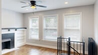 Located in Chicago's Edgewater neighborhood, this two-floor, 4-bedroom, 2-bathroom home blends classic character with modern updates throughout. The upper floor features warm hardwood flooring, a bright living room anchored by a striking fireplace with black tile surround, a mosaic tile hearth, and flanking built-in shelving — all complemented by recessed lighting, a ceiling fan, and a wall-mounted mini-split system. The galley-style kitchen is well-appointed with white shaker cabinetry, marble-look countertops, a subway tile backsplash, stainless steel appliances including a gas range, dishwasher, and microwave, plus rich hardwood floors. Bedrooms on this level feature hardwood floors, ceiling fans, closets, and mini-split units, with cast iron radiators adding period charm. The upper-level bathroom offers a subway-tiled tub surround and a crisp white vanity. The lower floor provides additional living space with light vinyl plank flooring, recessed lighting, and bedrooms with natural light from ground-level windows. The lower bathroom features large-format tile flooring, a glass-enclosed shower, and a clean white vanity. Hallways connect the spaces efficiently across both floors, making this a well-organized and functional home.