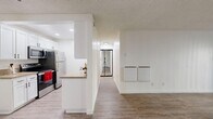 Located at 4445 Pacific Coast Hwy, this 2-bedroom, 1-bathroom unit is thoughtfully designed with a clean, modern aesthetic throughout its single floor. Wood-look flooring runs consistently across all living areas, complementing the bright white walls and textured ceilings.

The living room is a welcoming, open space highlighted by sliding glass doors that lead to a balcony, filling the room with natural light and providing outdoor views. The kitchen is efficiently laid out with white cabinetry featuring matte black hardware, granite-style countertops, a deep black undermount sink, and stainless steel appliances including a refrigerator — all connected to the main living area via a convenient pass-through counter.

Both bedrooms offer wood-look flooring and clean, neutral walls. The primary bedroom is a comfortable, well-proportioned space with a window that brings in natural light. The second bedroom is more compact yet equally bright and functional.

The bathroom is finished with a granite-topped white vanity, matte black fixtures, a large frameless mirror, and a shower-tub combination with glass sliding doors — maintaining the cohesive modern style found throughout the unit.

A central hallway connects all rooms efficiently, and the overall design prioritizes clean lines, neutral tones, and practical finishes.