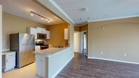 Located on 28th St N in Pinellas Park, Florida, this single-story residence offers a well-designed open layout that maximizes the sense of space throughout. Warm earth-toned walls are complemented by crisp white trim and crown molding, creating a cohesive and inviting aesthetic.

The kitchen is efficiently arranged with white cabinetry, a tile backsplash, and a full suite of stainless steel appliances, including a refrigerator, electric range, and built-in microwave. A peninsula with a built-in sink and light countertops extends into the main living area, providing both a functional workspace and a natural division between the kitchen and living spaces. Track lighting overhead ensures the kitchen is well-lit.

The living area is generously proportioned, featuring durable wood-style flooring, a ceiling fan, and multiple windows fitted with blinds that allow ample natural light. An arched architectural detail adds a subtle decorative element to the space. The bedrooms continue the wood-style flooring and are naturally lit by windows with outdoor views. The kitchen features light tile flooring, maintaining a clean and practical finish throughout.