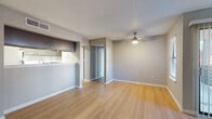 This single-floor residence in Doraville, GA, offers a clean, functional layout with a cohesive neutral color palette and light wood flooring that flows consistently throughout the space. The open living area is bright and spacious, anchored by a ceiling fan with integrated lighting and a textured ceiling. A pass-through peninsula connects the living area to the kitchen, creating an open, connected feel ideal for everyday living.

The kitchen is well-equipped, featuring gray shaker-style cabinetry, white subway tile backsplash, white quartz countertops, a double stainless steel sink, and stainless steel appliances including a refrigerator. A walk-in pantry or storage closet is accessible directly from the kitchen, adding valuable organizational space.

The bedrooms are comfortably sized with large windows that invite natural light and offer views of the surrounding greenery. The bathrooms are neatly appointed, with one featuring a gray vanity with a white countertop, framed mirror, and updated fixtures, while the second bathroom includes full tile surround on the tub-shower combination with matching gray cabinetry. Both bathrooms continue the warm wood flooring found throughout the home. Overall, the space presents a tidy, move-in-ready environment with modern finishes in a practical, well-organized floor plan.