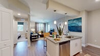 Located at 701 Little Palm Circle in Cape Coral, Florida, this single-story residence offers a thoughtfully designed open-concept layout that seamlessly connects the kitchen, dining, and living areas. The kitchen is appointed with granite countertops, white cabinetry, a stainless steel appliance suite including a refrigerator, range, microwave, and dishwasher, complemented by a subway tile backsplash. A peninsula with pendant lighting provides additional prep space and casual seating. Wood-style flooring flows through the main living areas, adding warmth and continuity throughout.

The living room is generously proportioned, featuring a ceiling fan, large windows that invite natural light, and neutral walls accented by bold color choices. Two bedrooms offer plush carpeting, ample natural light through well-positioned windows, and ceiling fans for comfort.

Both bathrooms are finished with granite-top vanities, white cabinetry, and large mirrors. The primary bathroom includes a glass-enclosed shower, while the secondary bathroom features a shower-tub combination. The overall ambiance is modern and inviting, reflecting a clean, contemporary aesthetic suited to Florida's relaxed lifestyle.
