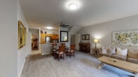 This single-floor residence offers a thoughtfully designed layout that balances comfort and functionality across its living spaces. The open-concept main area seamlessly connects the living room, dining area, and kitchen, all unified by light-toned wood-style flooring and neutral gray walls. The living room features a ceiling fan, textured ceiling, and a sliding glass door that invites natural light and provides outdoor access. The adjacent dining area accommodates a full dining set, while the kitchen offers generous cabinetry in warm honey-toned wood, stainless steel appliances including a refrigerator, range, microwave, and dishwasher, and ample counter space in a practical U-shaped configuration.

The primary bedroom includes vaulted ceilings, a ceiling fan, and an en-suite bathroom featuring a vanity with wooden cabinetry and a soaking tub. A second bedroom is equally well-proportioned, with large windows allowing natural light and direct access to an adjacent bathroom. The secondary bathroom includes a glass-enclosed walk-in shower, wood-style tile flooring, and clean, bright finishes. Throughout the residence, consistent flooring and a cohesive neutral palette create a calm, unified aesthetic.