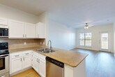 Located at 2104 Canal St in Houston's vibrant 77003 zip code, this one-bedroom, one-bathroom unit delivers a practical and comfortable layout across a single floor. The open-concept kitchen flows seamlessly into the combined dining and living area, creating a bright, connected space ideal for everyday living. The kitchen is well-appointed with white shaker cabinetry, granite-style countertops, a tiled backsplash, a peninsula with an integrated sink, and a full suite of stainless steel appliances including a refrigerator with ice maker, range, microwave, and dishwasher. Light wood-tone flooring runs throughout the main living areas, adding warmth and continuity. The living room benefits from natural light through large windows and a sliding door, with a ceiling fan overhead and an outdoor view. The bedroom is carpeted for comfort, features a ceiling fan, windows with exterior views, and a closet. The full bathroom includes a combined tub and shower, a granite-topped vanity, and wood-look flooring. Additional features include a dedicated laundry area, multiple closets for storage, and two hallways connecting the unit's spaces efficiently. The overall aesthetic is clean, neutral, and move-in ready.