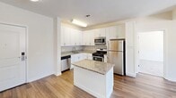 This contemporary apartment in Norwalk, CT offers 810 square feet of thoughtfully designed living space. The single-floor layout includes three bedrooms, two bathrooms, and an open-concept kitchen and living area. The primary bedroom, measuring 150 square feet, provides ample space for comfort.

The kitchen showcases modern amenities with white cabinetry, granite countertops, and stainless steel appliances, including a dishwasher and built-in microwave. A central island adds functionality and serves as a casual dining space. The living area features hardwood flooring, creating a seamless flow throughout the main living spaces.

Bedrooms are carpeted for comfort and include closet space with wire shelving systems. Large windows in the bedrooms and living areas allow for abundant natural light and offer picturesque views of the surrounding wooded landscape, particularly striking during winter months.

Bathrooms are designed with clean lines, featuring modern fixtures and ample counter space. The apartment's neutral color palette provides a blank canvas for personalization while maintaining a fresh, contemporary aesthetic. Climate control is facilitated by a central heating and cooling system, ensuring year-round comfort in this well-appointed Norwalk residence.