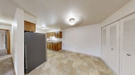 Located at 3125 West 4th Street in Appleton, Wisconsin, this single-floor residence offers a practical and functional layout with two bedrooms and two bathrooms. The combined kitchen and living area forms the heart of the home, where warm-toned oak cabinetry lines the galley-style kitchen, complemented by a stainless steel refrigerator, ample upper and lower cabinet storage, and a sink with countertop workspace. The tile flooring in the kitchen extends into the adjoining living area, creating a cohesive and easy-to-maintain common space. The living room is bright and open, featuring carpet flooring, a wall-unit air conditioner, baseboard heating, and a sliding glass door that floods the room with natural light and provides access to an outdoor area. Both bedrooms are carpeted and well-sized, with the primary bedroom offering a generous footprint, a closet with louvered doors, and natural light from a window. The second bedroom also features carpet, a window, and baseboard heating. The two bathrooms include a full bath with a tub/shower combination and tile flooring, and a second bath with tile floors and a vanity. The home's neutral color palette and functional design offer a clean, move-in-ready canvas throughout.