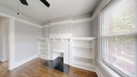 Located at 6257 North Lakewood Avenue in Chicago's Edgewater neighborhood, this three-bedroom, one-bathroom unit offers a thoughtful layout across a single floor. Rich hardwood floors run throughout, complemented by soft gray walls, crisp white trim, and generous crown molding that lend a cohesive, classic character to the space.

The living room features built-in shelving alongside a decorative fireplace surround, adding both charm and practical storage. Natural light pours in through large double-hung windows, offering neighborhood views of the surrounding Chicago streetscape. A hallway connects the rooms with an easy, functional flow.

The kitchen is well-appointed with white shaker cabinetry, dark granite countertops, a classic subway tile backsplash, and stainless steel appliances including a gas range, over-the-range microwave, and refrigerator. A large window ensures the kitchen remains bright throughout the day.

Each of the three bedrooms features hardwood floors, cast-iron radiators, and ample natural light from multiple windows. The primary bedroom is notably spacious, with a ceiling fan and corner window placement that enhances both airflow and light.

The bathroom is finished with timeless white tile and a classic black accent border, a full soaking tub with shower, and a window for natural ventilation. Throughout the unit, the combination of vintage architectural details and updated finishes creates a comfortable, character-filled home.