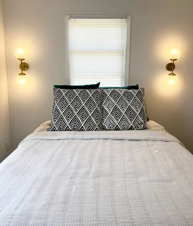 Queen sized bed in bedroom with scones with remote control lights - 1217 Landon Ave