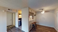Located at 5604 Cotswold Hills Dr in Fort Worth, TX, this single-story unit presents a practical and well-organized layout with a variety of functional features throughout. The living room serves as the central gathering space, highlighted by a full brick accent wall with a wood-burning fireplace that adds a classic, warm focal point to the room. Wood-look laminate flooring runs consistently through the main living areas and bedrooms, providing a cohesive and easy-to-maintain surface underfoot. Textured popcorn ceilings are present throughout, and a ceiling fan with light fixture keeps the dining and common areas comfortable year-round.

The kitchen is configured as a galley-style space with tile flooring, ample upper cabinetry, light countertops, a stainless sink, and black appliances including a refrigerator and range. A pass-through bar with seating connects the kitchen to the adjacent dining area, enhancing the open feel between spaces. Notably, the kitchen also accommodates an in-unit washer and dryer, adding significant convenience. The bedroom features wood-look flooring, neutral walls, a ceiling vent, and access to a walk-in closet with built-in shelving. The bathroom includes a vanity with a framed mirror, tile flooring, and a shower-tub combination.