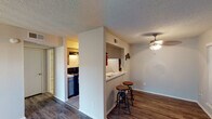Located at 5604 Cotswold Hills Dr in Fort Worth, TX, this single-story unit presents a practical and well-organized layout with a variety of functional features throughout. The living room serves as the central gathering space, highlighted by a full brick accent wall with a wood-burning fireplace that adds a classic, warm focal point to the room. Wood-look laminate flooring runs consistently through the main living areas and bedrooms, providing a cohesive and easy-to-maintain surface underfoot. Textured popcorn ceilings are present throughout, and a ceiling fan with light fixture keeps the dining and common areas comfortable year-round.

The kitchen is configured as a galley-style space with tile flooring, ample upper cabinetry, light countertops, a stainless sink, and black appliances including a refrigerator and range. A pass-through bar with seating connects the kitchen to the adjacent dining area, enhancing the open feel between spaces. Notably, the kitchen also accommodates an in-unit washer and dryer, adding significant convenience. The bedroom features wood-look flooring, neutral walls, a ceiling vent, and access to a walk-in closet with built-in shelving. The bathroom includes a vanity with a framed mirror, tile flooring, and a shower-tub combination.