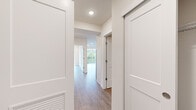 Located at 3710 S Angeline St in Seattle, WA, this thoughtfully designed 2-bedroom, 1-bathroom residence offers a clean, modern aesthetic throughout its single-floor layout. Wood-look flooring runs continuously across the space, complemented by crisp white walls, recessed lighting, and Shaker-style interior doors that lend a cohesive, contemporary feel.

The open kitchen is a standout feature, equipped with stainless steel appliances including a gas range, over-the-range microwave, and refrigerator. White shaker cabinetry, a classic subway tile backsplash, and a white quartz peninsula countertop with an integrated sink make this kitchen both functional and visually appealing. A mini-split unit provides efficient climate control for the living area.

The primary bedroom features a large picture window that fills the room with natural light and frames views of surrounding greenery and the neighborhood. A ceiling fan adds comfort, and the room connects to a dedicated closet with built-in shelving. The second bedroom is compact and bright, with its own wall heating unit. Two hallways connect the rooms efficiently, adding to the overall sense of flow.

The bathroom includes gray tile flooring, a tub-shower combination with full subway tile surround, and sliding glass doors with brushed nickel hardware — clean and practical in design.