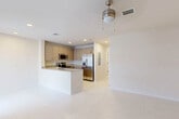 Located at 624 NE 2nd St in Dania Beach, FL, this single-floor, 2-bedroom, 2-bathroom home offers a clean, contemporary design throughout. Large-format light-colored ceramic tiles span the main living areas, reflecting natural light and creating a bright, airy ambiance. Ceiling fans are present in multiple rooms, enhancing comfort in Florida's warm climate.

The open-concept kitchen is a standout feature, equipped with a full suite of stainless steel appliances including a side-by-side refrigerator with ice dispenser, electric range, and over-the-range microwave. Warm-toned cabinetry pairs with granite countertops, and a peninsula with a sink adds both prep space and a natural divide between the kitchen and living area.

The primary bedroom offers generous proportions, with a ceiling fan and access to a closet. A second bedroom features a sliding glass door that opens to an outdoor view of lush greenery, bringing the Florida landscape indoors. Both bedrooms are served by their own bathrooms, each featuring a tub-shower combination with full tile surrounds in a neutral palette.

Two closets provide practical storage throughout the home. The overall design is clean, minimal, and move-in ready, making this Dania Beach residence a well-appointed and functional home.