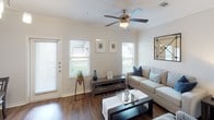 This single-story residence offers a thoughtfully designed layout that balances comfort and functionality. The living room serves as the heart of the home, featuring rich hardwood-style flooring, crown molding, a ceiling fan, and multiple windows with blinds that invite abundant natural light. The space is well-proportioned, providing ample room for relaxing and entertaining.

The kitchen is outfitted with dark espresso cabinetry, granite countertops, and a full suite of stainless steel appliances, including a refrigerator, range, and microwave. Crown molding and track lighting add a polished touch, while a pantry closet and in-unit washer and dryer hookup provide excellent storage and convenience.

Both bedrooms are generously sized, each equipped with a ceiling fan and windows that allow natural light to filter in. The hardwood-style flooring continues throughout, contributing to a cohesive aesthetic. One bedroom connects directly to a spacious bathroom featuring a dual-sink vanity with granite countertops, dark cabinetry, and a separate water closet. A second bathroom includes a tiled shower/tub combination. The neutral color palette and clean finishes throughout lend the space a calm, modern ambiance.