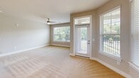 This well-appointed 2-bedroom, 2-bathroom residence in Charlotte, NC offers a thoughtfully designed single-level layout that balances comfort and functionality. The open-concept kitchen serves as a central hub, showcasing granite countertop surfaces, a large island with a built-in sink and pendant lighting overhead, taupe cabinetry, a classic white subway tile backsplash, and stainless steel appliances including a refrigerator with ice maker, electric range, and microwave. Wood-look flooring runs throughout the kitchen and living areas, lending warmth and continuity to the space. The living room is bright and welcoming, featuring a ceiling fan, large windows with outdoor views of lush greenery, and a glass-panel door that opens to a private balcony. The spacious primary bedroom includes a distinctive bay window arrangement that floods the room with natural light, plush carpeting, and access to a well-organized walk-in closet with wire shelving. The primary bathroom features a dual-sink granite vanity, a walk-in shower, and wood-look flooring. The second bedroom is cozy and well-lit with a ceiling fan, carpeted floors, and a window overlooking greenery. The second bathroom offers a single granite vanity and a shower-tub combination. Two closets and a hallway complete this efficiently designed home.