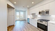 Located at 2260 El Cajon Boulevard in San Diego's vibrant North Park neighborhood, this modern one-bedroom, one-bathroom unit offers a thoughtfully designed open-concept layout with clean lines and contemporary finishes throughout. Light wood-tone flooring flows seamlessly across the entire space, complementing the crisp white walls and recessed lighting overhead.

The combined kitchen, dining, and living area forms the heart of the unit. The kitchen is outfitted with sleek white flat-front cabinetry, white quartz countertops, a tiled backsplash, and a full suite of stainless steel appliances including a gas range, microwave, dishwasher, and French door refrigerator. A private balcony accessed through glass-panel doors extends the living space outdoors and offers open views of the surrounding San Diego cityscape.

The bedroom is bright and airy, featuring large floor-to-ceiling windows that frame sweeping elevated views of the neighborhood and beyond, filling the room with abundant natural light. A dedicated closet provides convenient built-in storage.

The bathroom is finished in a clean, modern style with a glass-enclosed walk-in shower tiled in neutral tones, a floating white vanity with an integrated sink, and wood-look flooring. An in-unit laundry area and a hallway complete the layout, offering practical everyday functionality within a compact yet efficiently organized floor plan.