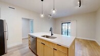 Located at 105 Laurel Hill Rd in Brookfield, CT, this thoughtfully designed two-bedroom, two-bathroom residence offers a clean, modern aesthetic across a single floor. Light hardwood flooring flows consistently throughout, unifying the space with a warm, contemporary feel.

The kitchen stands out as a central feature, showcasing warm natural wood cabinetry, a quartz-topped island with an undermount sink and matte black faucet, stainless steel appliances, and globe pendant lighting — combining style with everyday functionality.

Both bedrooms are bright and well-proportioned, featuring large black-framed windows that invite abundant natural light. The generously sized primary bedroom offers views of the surrounding landscape, while the second bedroom provides comfortable accommodations with similar window detailing.

The two bathrooms are finished with modern tile surrounds, glass-enclosed walk-in showers with grab bars, warm wood vanities, and quartz countertops — delivering a clean, spa-like atmosphere. A dedicated laundry room with full-size washer and dryer adds convenience. A hallway and closet round out the efficient, functional layout, making this residence a well-appointed home in Brookfield, Connecticut.