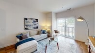 This single-floor residence at 301 N La Fox St in South Elgin, Illinois offers a thoughtfully designed layout with modern finishes and a bright, open atmosphere. The open-concept kitchen is a standout feature, outfitted with crisp white shaker cabinetry, a classic subway tile backsplash, quartz countertops, and a full suite of stainless steel appliances including a French door refrigerator, gas range, built-in microwave, and dishwasher. A generously sized island with bar seating and globe pendant lighting above adds both function and style. Warm hardwood-style flooring flows throughout the main living areas, connecting the kitchen seamlessly to the living room. The living room is bright and welcoming, featuring a large sliding glass door that opens to a private balcony and fills the space with natural light. Two well-proportioned bedrooms offer plush carpeting, windows with outdoor views, and a calm, restful ambiance. The bathroom is clean and contemporary, featuring a floating vanity with white quartz countertop, a large mirror, and coordinating hardwood-style flooring. The overall design palette — crisp whites, warm wood tones, and soft neutrals — lends a cohesive, modern feel throughout the entire residence.
