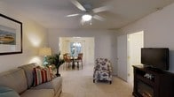 Located at 215 Whitehall Ln in Jacksonville, North Carolina, this two-floor home presents a thoughtfully arranged layout that balances comfort and functionality. The main living area is open and inviting, featuring plush carpeting and a ceiling fan with integrated lighting that anchors the room. It flows naturally into an adjacent dining area, which benefits from a chandelier and access to natural light through curtained windows and a front-facing door, creating a warm and welcoming atmosphere. The transition between these spaces is seamless, making the area ideal for both relaxing and entertaining. The floor plan reveals multiple rooms across the layout, including bedrooms with carpeted flooring and a bathroom with standard fixtures. Neutral wall tones are carried throughout, lending a clean and cohesive aesthetic to the interior. The upper level extends the living space further, adding versatility to the home's overall footprint. Generous doorways and an efficient use of space contribute to an easy flow between rooms. The combination of soft textures, practical finishes, and a well-connected floor plan makes this Jacksonville home a functional and comfortable residence.