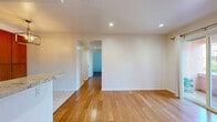 Located at 4810 S La Brea Ave in Los Angeles, this single-floor 2-bedroom, 2-bathroom home offers a well-organized layout with a clean, modern aesthetic throughout. Warm-toned hardwood flooring runs continuously through the living areas and bedrooms, lending a cohesive and inviting feel to the space.

The combined kitchen and living room serves as the heart of the home. The kitchen is well-appointed with rich wood cabinetry, a subway tile backsplash, stainless steel appliances including a full-size refrigerator with ice maker and a range, and a granite-topped peninsula that doubles as a breakfast bar. A statement pendant light fixture adds a touch of elegance overhead. Light tile flooring grounds the kitchen area, transitioning seamlessly to the hardwood of the living space, which features a sliding glass door providing direct access to an outdoor patio.

Both bedrooms are bright and airy, each benefiting from natural light through sizable windows with views of surrounding greenery. The primary bedroom includes access to a dedicated walk-in closet with built-in shelving. The two bathrooms are finished with tasteful stone-look tile flooring; one features a double-sink vanity with granite countertops and framed mirrors, while the other includes a subway-tiled tub/shower combination. A hallway connects the rooms efficiently, completing this well-designed home.