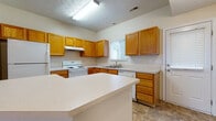 Located at 3675 Cross Ridge Ln in Canal Winchester, Ohio, this two-story home offers a practical and comfortable layout designed for everyday living. The kitchen serves as a central hub of the main floor, outfitted with warm oak cabinetry, light countertops, white appliances including a range, dishwasher, and refrigerator, and a peninsula island that provides additional workspace and a natural transition into the adjacent living area. Tile flooring runs throughout the kitchen, while the living space features plush wall-to-wall carpeting, creating a welcoming and cohesive flow between the two areas. Natural light filters in through blinds-fitted windows, brightening the neutral, light-toned walls throughout the home. The bedrooms are generously proportioned, each with soft carpeting, ample wall space, and windows that offer views of the surrounding greenery. The bathrooms maintain a consistent design language with oak vanity cabinetry, light countertops, and tile flooring. One bathroom includes a full tub-shower combination, while another serves as a half bath. The upper floor, accessible via an interior staircase, expands the overall living space considerably. A back door off the kitchen provides convenient exterior access. The home's clean, neutral palette and consistent finishes make it a versatile and move-in ready residence.