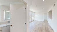 Located at 4806 Oakwood Ave in Los Angeles, CA, this thoughtfully designed 3-bedroom, 2-bathroom unit offers a clean, modern aesthetic across a single floor. Light wood flooring flows seamlessly throughout, complementing the crisp white walls and recessed lighting that illuminate every room.

The living area is bathed in natural light through large windows that frame views of the surrounding neighborhood and mature trees. The kitchen features sleek white flat-front cabinetry, stone countertops, a stainless steel undermount sink, a tile backsplash, and stainless steel appliances including a gas range and dishwasher.

The three bedrooms each benefit from abundant natural light, with windows offering pleasant outdoor views. The primary bedroom includes a walk-in closet, adding practical storage. The two bathrooms are finished with large-format neutral tile surrounding deep soaking tubs with integrated showers and chrome fixtures, conveying a clean and contemporary feel.

A hallway connects the rooms efficiently, maintaining a cohesive flow throughout the unit. The overall design emphasizes minimalism and functionality, with consistent finishes that create a bright, airy ambiance well-suited to the Los Angeles lifestyle.