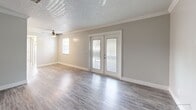 Located at 1301 Inland Seas Blvd in Winter Garden, Florida, this 2-bedroom, 1-bathroom single-story home offers a clean, modern aesthetic throughout. The interior is finished with durable wood-look luxury vinyl flooring, neutral gray walls, crisp white crown molding, and textured ceilings — creating a bright and cohesive look from room to room.

The combined dining and living area is open and airy, featuring a ceiling fan and French doors that lead out to a private patio, allowing natural light to flow freely into the space. The galley-style kitchen is well-appointed with warm wood-toned cabinetry, quartz countertops, a subway tile backsplash, stainless steel appliances including a refrigerator, range, microwave, and dishwasher, along with a stainless steel sink.

Both bedrooms are comfortably sized, each with windows fitted with blinds that bring in natural light and offer outdoor views. Each bedroom includes a dedicated closet, providing ample storage. The primary bedroom features its own closet with louvered doors.

The bathroom is thoughtfully designed with a quartz-top vanity, wood-toned cabinetry, brushed nickel fixtures, and a full tub-shower combination with white tile surround. The matching flooring ties the bathroom seamlessly to the rest of the home's interior design.