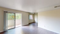 This single-floor residence offers a thoughtfully designed layout that balances comfort and functionality throughout its key living spaces. The open living and dining area serves as the heart of the home, featuring durable wood-style flooring, neutral cream-toned walls, and a ceiling fan for year-round comfort. Abundant natural light pours in through multiple windows and a sliding glass door that opens directly onto a private balcony overlooking lush greenery — creating a seamless indoor-outdoor connection. The galley-style kitchen is well-equipped with rich dark cabinetry, granite-look countertops, stainless steel appliances including a refrigerator, electric range, and built-in microwave, all set atop light wood-style flooring. Two bedrooms provide quiet retreats, each finished with plush carpeting, sliding closet doors, and windows that bring in natural light and outdoor views. The full bathroom is clean and functional, featuring a tub-shower combination with a brushed nickel fixture, a handheld showerhead, and coordinating hardware throughout. The overall ambiance is clean, bright, and move-in ready, offering a comfortable and practical living environment.