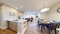 Located at 500 Apex Dr in Windsor, Colorado, this well-appointed 2-bedroom, 2-bathroom residence offers a thoughtfully designed single-level layout. The modern kitchen is a standout feature, showcasing light wood-tone cabinetry, a subway tile backsplash, stainless steel appliances including a range and over-the-range microwave, and a peninsula with a quartz countertop and undermount sink — ideal for both cooking and casual dining. Wood-look flooring runs throughout the main living areas, adding warmth and continuity.

The open living room is bright and inviting, with recessed lighting, a sleek fireplace, and direct access to a private balcony through a glass door flanked by windows that bring in generous natural light. Both bedrooms feature plush carpeting, ceiling fans, and windows that allow ample daylight. The primary bedroom includes a barn-style sliding closet door, adding a modern touch.

The two bathrooms are finished with light wood vanities, quartz countertops, and tile accents. One bathroom features a full tub-shower combination with white subway tile surround. An in-unit laundry area with a stacked washer and dryer adds everyday convenience. Three closets provide ample storage throughout the residence.