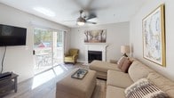 Located at 222 Old Fayetteville Rd in Carrboro, NC, this single-floor residence offers a thoughtfully designed layout with modern finishes throughout. The open-concept living area centers around a classic white-mantled fireplace and features wood-look flooring, a ceiling fan, and a sliding glass door that floods the space with natural light and opens to a private balcony with outdoor seating. The kitchen is equipped with stainless steel appliances, white shaker-style cabinetry, granite countertops, a breakfast bar with seating, and stylish pendant and track lighting overhead. Adjacent to the kitchen, a dedicated dining area features wood-look flooring, a chandelier, and built-in shelving, adding both function and charm. The two bedrooms are carpeted and well-sized, each offering a calm, neutral palette. One bedroom benefits from a window with outdoor views. The unit includes two bathrooms, both finished with granite-topped white vanities and wood-look flooring. The primary bathroom features a shower with a curtain, while the second bathroom offers a clean, accessible layout with a single vanity and grab bar. Together, the spaces create a comfortable and cohesive living environment.
