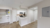 This well-appointed one-bedroom, one-bathroom residence at 2301 NW 122nd St in Oklahoma City, OK, offers a thoughtfully designed single-floor layout with a clean, neutral aesthetic throughout. Wood-look flooring flows seamlessly through every room, complementing the warm, light-toned walls and crisp white trim.

The open living room is a welcoming centerpiece, featuring a ceiling fan, a tile-surround fireplace, and multiple windows that fill the space with natural light. A sliding glass door leads to a private balcony, extending the living area outdoors. The layout connects naturally to the kitchen, which is outfitted with white shaker-style cabinetry, quartz countertops, a stainless steel undermount sink, and stainless steel appliances including a refrigerator, range, and microwave.

The bedroom is a comfortable retreat with its own ceiling fan, a sliding door to the balcony, and access to a dedicated closet featuring built-in shelving and hanging rods for organized storage. The bathroom is finished with a white vanity with quartz countertop, brushed nickel fixtures, a large mirror, and a full tub-shower combination with tile surround. Two hallways connect the rooms efficiently, and a paneled front entry door provides a clean, secure entryway.