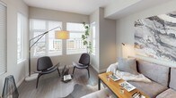 Located at 2155 Kettner in San Diego, this model unit on the fifth floor presents a well-designed, single-story layout that balances contemporary style with functional living. The open-concept living area is bathed in natural light from multiple large windows fitted with horizontal blinds, offering views of the surrounding San Diego cityscape. Wood-look flooring runs throughout the main living spaces, lending warmth and continuity to the interior.

The kitchen is thoughtfully appointed with two-tone cabinetry — crisp white upper cabinets paired with dark lower cabinets — complemented by white quartz countertops and a subtle subway tile backsplash. Stainless steel appliances, including a gas range, microwave, dishwasher, and side-by-side refrigerator, complete the modern culinary space.

The living area flows naturally into a dedicated sitting nook framed by oversized windows with city views, ideal for a reading or lounge corner. Two bedrooms feature plush carpeting, neutral wall tones, and ample closet space, with the primary bedroom including a walk-in closet. The bathroom offers a clean, modern aesthetic with a wide vanity, large mirror, and glass-enclosed walk-in shower. Throughout, the design maintains a cohesive, contemporary palette of soft grays and warm neutrals.