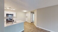 Located at 813 Stadium Dr in Wake Forest, NC, this single-floor residence offers a thoughtfully designed open-concept layout that seamlessly connects the main living areas. The kitchen is outfitted with white shaker-style cabinetry, stainless steel appliances including a refrigerator, range, and microwave, a classic white subway tile backsplash, and a light stone-look countertop that extends to a peninsula with an undermount sink — ideal for both cooking and casual dining. Wood-look flooring runs throughout the main living spaces, lending warmth and continuity to the interior. The living room is anchored by a fireplace with a white mantel surround, creating a welcoming focal point, while a sliding glass door allows natural light to filter in. Additional living space features neutral warm-gray walls, textured ceilings, and windows that bring in natural light. The bathrooms are clean and functional, each featuring a soaking tub and shower combination with curved curtain rods, white tile surrounds, and brushed nickel hardware and towel bars. The overall aesthetic is bright, neutral, and move-in ready, offering a comfortable and practical living environment.