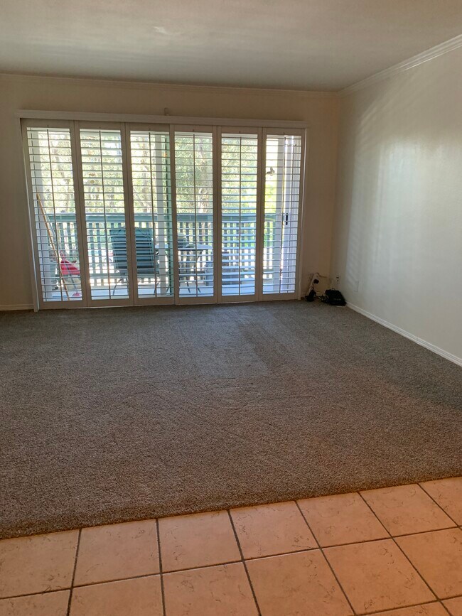 Sala de estar con contraventanas tipo persiana y nuevas puertas corredizas de vidrio doble acristalado de vinilo blanco - 436 N Bellflower Blvd
