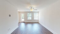 This three-story residence at 188–198 Kettle Point Ave in East Providence, Rhode Island, offers a well-organized layout spread across multiple levels, combining functional design with contemporary finishes. The ground level includes an attached garage equipped with an automatic opener, a concrete floor, and an electrical panel, providing secure parking and additional storage space.

The main living level showcases rich, dark hardwood-style flooring that flows through the open living area, which is bathed in natural light from multiple windows and a glass-paneled door leading to an exterior deck or balcony. A ceiling fan anchors the living space, contributing to both comfort and airflow. The kitchen is a standout feature, outfitted with dark cabinetry, granite countertops, stainless steel appliances including a refrigerator, range, microwave, and dishwasher, and a peninsula with a undermount sink. A large window provides ample natural light. The bathroom on this level features classic black-and-white hexagonal tile flooring, a tub-shower combination with brushed nickel fixtures, and a vanity.

The upper floor includes carpeted bedrooms with natural light from windows overlooking the surrounding neighborhood, offering a quiet, comfortable retreat.