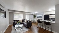 Located at 3333 Naylor Rd in Temple Hills, Maryland, this single-floor residence offers a thoughtfully designed open-concept layout that seamlessly connects the living, dining, and kitchen areas. The living room is bright and welcoming, featuring large windows with vertical blinds that invite an abundance of natural light, wood-style flooring throughout, and neutral grey walls that create a clean, contemporary aesthetic.

The kitchen is equipped with white cabinetry, granite countertops, black appliances including a gas range and refrigerator, and a peninsula with bar seating — ideal for casual dining or entertaining. A dedicated dining area sits adjacent, providing a natural flow for hosting.

The residence includes two bedrooms, each finished with wood-style flooring, soft neutral walls, and windows that allow for ample natural light. One bedroom features space for a home office setup, adding functional versatility.

The bathroom is tastefully updated with a tiled tub-surround in a warm taupe tone, granite vanity countertop, dark cabinetry, and coordinating tile flooring, offering a clean and polished finish.

Throughout the space, consistent flooring, a cohesive neutral color palette, and modern fixtures contribute to a comfortable and contemporary living environment.