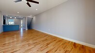 This well-appointed three-floor home offers a generous layout across three distinct levels, providing ample space for comfortable living. The main level is anchored by a bright, open living room featuring beautiful light hardwood flooring, recessed lighting, a sleek tile-surround fireplace, and sliding glass doors that open to an outdoor deck with natural views. The kitchen is a standout, showcasing grey shaker-style cabinetry, white subway tile backsplash, quartz countertops, a large peninsula with pendant lighting, and stainless steel appliances — all set over the same warm hardwood floors that carry throughout the main level. A dedicated entrance and hallways provide smooth circulation between spaces. The three bathrooms are finished with grey shaker vanities, white quartz countertops, and matte black hardware, with flooring ranging from wood-look vinyl to tile. The three bedrooms feature plush carpeting and large windows that invite natural light. The lower level offers an expansive additional living area with hardwood-style flooring and recessed lighting — ideal as a recreation room or home office. Two staircases connect the floors seamlessly, making this home as functional as it is stylish.