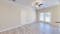 Located at 201 Tiliwa Ct in Clemson, SC, this single-floor home offers a clean, well-maintained interior with a cohesive design aesthetic throughout. The living areas feature light-toned hardwood-style flooring, warm neutral wall colors, and crown molding, creating a welcoming and polished atmosphere. Ceiling fans are present in the main living spaces, providing both function and style.

The kitchen is a standout feature, offering rich cherry wood cabinetry, granite countertops, and stainless steel appliances including a refrigerator, range, and microwave. A skylight enhances the kitchen with additional natural light, and tile flooring completes the practical yet attractive space.

The dining area showcases tile flooring, chair-rail molding, and a large window with natural light. Additional rooms feature light wood flooring, pendant lighting, and ample closet storage, including a walk-in closet in at least one bedroom. French doors in the main living area lead to the outdoors, further brightening the space.

The bathroom is well-appointed with granite countertops, rich cabinetry matching the kitchen, a large vanity mirror, and tile flooring. Natural light fills the bathroom through a tall window. Throughout the home, white trim and neutral tones create a bright, airy ambiance suited to a variety of lifestyles.