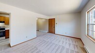 Located at 6300 West Bancroft Street in Toledo, Ohio, this single-floor, one-bedroom, one-bathroom unit offers a practical and well-organized layout. The combined kitchen and living area forms the heart of the space, with the kitchen featuring warm oak cabinetry, a stainless steel GE electric range, light granite-style countertops, a double basin sink, and light-toned vinyl plank flooring. A skylight above the kitchen passageway allows natural light to filter in. The open living area is carpeted throughout and includes a baseboard heating unit and a wall-mounted air conditioning unit, along with a window offering outdoor views. The bedroom is a comfortable, carpeted space with a set of sliding wood-panel closet doors, a window with natural light, and a baseboard heater beneath it. The full bathroom includes a tub and shower combo with chrome fixtures, a wood-vanity with a light countertop, and wood-toned vinyl plank flooring. Throughout the unit, warm wood trim accents and white walls maintain a clean, consistent aesthetic. The textured ceilings and neutral tones create a straightforward and functional living environment suited for everyday comfort.