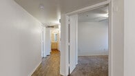 This single-floor, 3-bedroom, 2-bathroom residence offers a thoughtfully designed layout that balances comfort and functionality. The living room serves as the focal point of the home, highlighted by vaulted ceilings, wood-look flooring, a tiled fireplace, and a large window that fills the space with natural light and outdoor views of surrounding greenery.

The kitchen features light wood cabinetry, white appliances including a refrigerator, range, microwave, and dishwasher, along with light countertops, track lighting, and a window above the sink. Wood-look flooring carries through this space, creating a cohesive feel.

The three bedrooms are carpeted and each include ceiling fans, vertical blinds, and windows that provide natural light. The spacious primary bedroom features its own access to a well-appointed bathroom with a long vanity, ample cabinet storage, wood-look flooring, and an adjacent walk-in closet. The second bathroom includes a tiled shower/tub combination, a single-sink vanity, and matching light finishes throughout.

A central hallway with wood-look flooring connects the bedrooms and bathrooms, with closets providing additional storage. The overall aesthetic is clean and neutral, with white walls and consistent light-toned finishes creating a bright, move-in-ready atmosphere throughout.