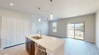 Located in Corinth, TX, this single-story 2-bedroom, 2-bathroom home offers a well-designed open-concept layout. The kitchen serves as the heart of the home, featuring rich dark-espresso cabinetry, white quartz countertops, a center island with an undermount sink, subway tile backsplash, and a full suite of stainless steel appliances including a refrigerator, range, built-in microwave, and dishwasher. Sleek pendant lighting illuminates the island, adding a modern touch. The kitchen flows seamlessly into the dining and living areas, where light wood-look flooring and neutral tones create a bright, cohesive atmosphere. Sliding glass doors lead to a private patio with outdoor views, filling the living space with natural light. The primary bedroom offers plush carpeting, a ceiling fan, and a dedicated closet, while the second bedroom features light hardwood-style flooring and a ceiling fan. Both bedrooms are served by well-appointed bathrooms with dark cabinetry and light countertops; one bathroom includes a soaking tub surrounded by classic white subway tile. A dedicated laundry area and hallway provide added convenience and functionality throughout this efficiently designed home.