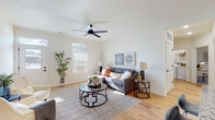 Located at 1000 Hartman Circle in Saint Peters, Missouri, this single-story home offers a thoughtfully designed open-concept layout that promotes a bright, airy atmosphere throughout. The living room serves as the heart of the home, featuring light hardwood flooring, crisp white walls, and multiple windows that invite generous natural light. A sleek ceiling fan anchors the space, which flows seamlessly toward the front entry.

The kitchen is a standout feature, equipped with tall white shaker cabinetry, granite countertops, a subway tile backsplash, and a full suite of stainless steel appliances. A large center island with a bold navy base and granite top provides additional prep space and casual seating, making it ideal for both cooking and entertaining.

A dedicated office nook offers a quiet retreat, while the bedroom features plush carpeting, ample natural light from a large window, and a ceiling fan for added comfort. The bathroom is finished with a wide white vanity, an integrated sink, a large mirror, and a glass-enclosed shower. A dedicated laundry closet with side-by-side washer and dryer adds everyday convenience, completing this well-appointed home.
