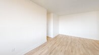 Located at Fowler Drive in Mississauga's Erin Mills area, this well-appointed three-bedroom, two-bathroom unit offers a clean, modern aesthetic across a thoughtfully laid-out single floor. The kitchen is a standout feature, designed in a galley style with crisp white shaker cabinetry, dark countertops, white subway tile backsplash, and stainless steel appliances including a large French door refrigerator. A peninsula counter extends into the open living area, creating a natural transition between the kitchen and the main living space. The living area is bright and airy, benefiting from a generous bank of floor-to-ceiling windows that frame views of blooming trees and the outdoors, while baseboard heating runs neatly beneath the sill. Light wood-toned flooring flows throughout the main living spaces and bedrooms, contributing to the home's fresh, contemporary feel. The primary bedroom is a comfortable size, featuring large windows that bring in natural light. The two additional bedrooms are well-proportioned with clean white walls and light flooring. Both bathrooms are finished in white, with one featuring a white vanity with under-cabinet storage, a large mirror, and tile flooring, and the other including a soaker tub with white subway tile surround. A balcony provides outdoor access with open views of the surrounding greenery.