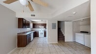 Located in El Paso, TX, this two-story home offers three bedrooms and two bathrooms thoughtfully distributed across two equally apportioned floors. Light-toned tile flooring runs throughout the main level, creating a clean and cohesive look. The kitchen is well-appointed with rich dark-wood cabinetry, granite-style countertops, a white gas range, dishwasher, and ample storage. It opens directly to the dining area, which benefits from a ceiling fan and natural light from a nearby window, making the space feel airy and connected. A staircase leads to the upper floor, where the bedrooms are situated. The primary bedroom offers a comfortable footprint with a closet featuring a full-width hanging rod for generous storage. The additional bedrooms are bright and well-sized, each with ceiling fans and windows that bring in natural light. Both bathrooms are cleanly finished, with one featuring a full tub-shower combination. A dedicated laundry area on the main floor houses a full-size washer and dryer side by side, adding everyday convenience. Textured ceilings and neutral wall tones carry throughout, giving the home a consistent, move-in-ready feel suited for practical, comfortable living.