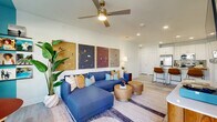 Located in San Antonio, TX, this well-designed one-bedroom, one-bathroom unit offers a thoughtfully planned single-floor layout that maximizes both functionality and style. The open-concept living and kitchen area serves as the heart of the home, where light wood-look flooring, recessed lighting, and a neutral color palette create a bright and welcoming atmosphere. The kitchen is outfitted with white shaker cabinetry, stainless steel appliances, subway tile backsplash, and a granite-topped island with bar seating — ideal for both cooking and casual dining. The living room features a bold teal accent wall, large windows that bring in natural light and outdoor views, and a ceiling fan overhead. The bedroom is a comfortable retreat with plush carpeting, a striking teal ceiling detail, and generous windows that frame outdoor views. A dedicated closet provides ample storage. The bathroom offers a clean, modern design with granite countertops, white cabinetry, and a tiled tub/shower combination. Additional conveniences include an in-unit laundry area and a private patio, rounding out this efficiently designed and attractively finished residential unit.