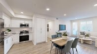 Located in Murrieta, CA, this well-appointed 2-bedroom, 2-bathroom single-story home offers a thoughtfully designed open-concept layout with modern finishes throughout. The kitchen is a standout feature, showcasing crisp white shaker cabinetry, grey quartz countertops, a classic subway tile backsplash, stainless steel appliances including a gas range and over-the-range microwave, and light wood-style flooring that flows seamlessly into the dining and living areas. The living room is bright and airy, benefiting from natural light and a clean, neutral color palette. The primary bedroom is generously sized, featuring plush carpet, multiple windows with natural light, and access to a dedicated closet with built-in shelving. The secondary bedroom is equally comfortable, with carpeted floors and a window framing outdoor greenery. Both bathrooms are finished with wood-style flooring and include tub-shower combinations. A hallway connects the living spaces to the private bedrooms, enhancing the functional flow of the home. The overall ambiance is fresh, modern, and move-in ready, reflecting a cohesive contemporary design ideal for comfortable everyday living.