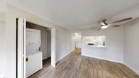 Located at 18201 NW Heritage Pkwy in Beaverton, Oregon, this two-floor residence offers a well-organized and functional layout with clean, neutral finishes throughout. The main living area features wood-look flooring, a ceiling fan, and a baseboard heating system, creating a comfortable and practical space. A pass-through window connects the living area to the kitchen, which is outfitted with white shaker-style cabinetry, light countertops, and a stainless steel refrigerator — offering an efficient and bright workspace. Sliding glass doors in the living area open to a private balcony, allowing natural light to fill the room and providing outdoor views of surrounding greenery. An in-unit stacked washer and dryer is conveniently tucked into a dedicated closet off the main living space. The bedrooms are carpeted for comfort, each featuring ceiling fans and windows that bring in natural light, with one bedroom including a built-in closet with shelving. The bathroom is well-appointed with a full tub and shower combination, a white vanity with under-cabinet storage, and wood-look flooring that ties the space together. Textured ceilings are consistent throughout the unit, adding a classic character to the home's overall aesthetic.