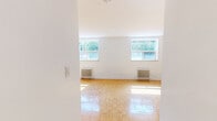 Located at 18 Skipton Crt, Unit 101 in Toronto's northwest end, this single-floor unit offers a thoughtfully arranged layout designed for efficient everyday living. The main living area is a welcoming, open space characterized by warm parquet flooring laid in a classic basket-weave pattern that adds a timeless charm to the interior. Bright white walls keep the space feeling clean and airy, while large windows allow generous natural light to pour in and offer views of the surrounding greenery. A classic cast-iron radiator provides reliable, comfortable heating. The kitchen is well-appointed with crisp white shaker-style cabinetry, grey countertops, a subway tile backsplash, and stainless steel appliances including a refrigerator, stove, and microwave. Light tile flooring in the kitchen complements the overall clean aesthetic. A connecting hallway links the living and kitchen areas, providing functional flow throughout the unit. The space is finished with clean white trim and baseboards throughout, contributing to a cohesive and polished look. Overall, the unit presents a bright, practical, and neatly maintained living environment in a residential Toronto neighbourhood.