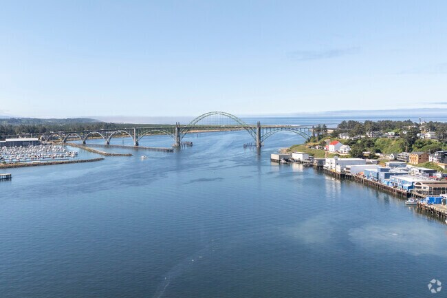 Yaquina Bay's bridge arches over a marina filled with fishermen.
